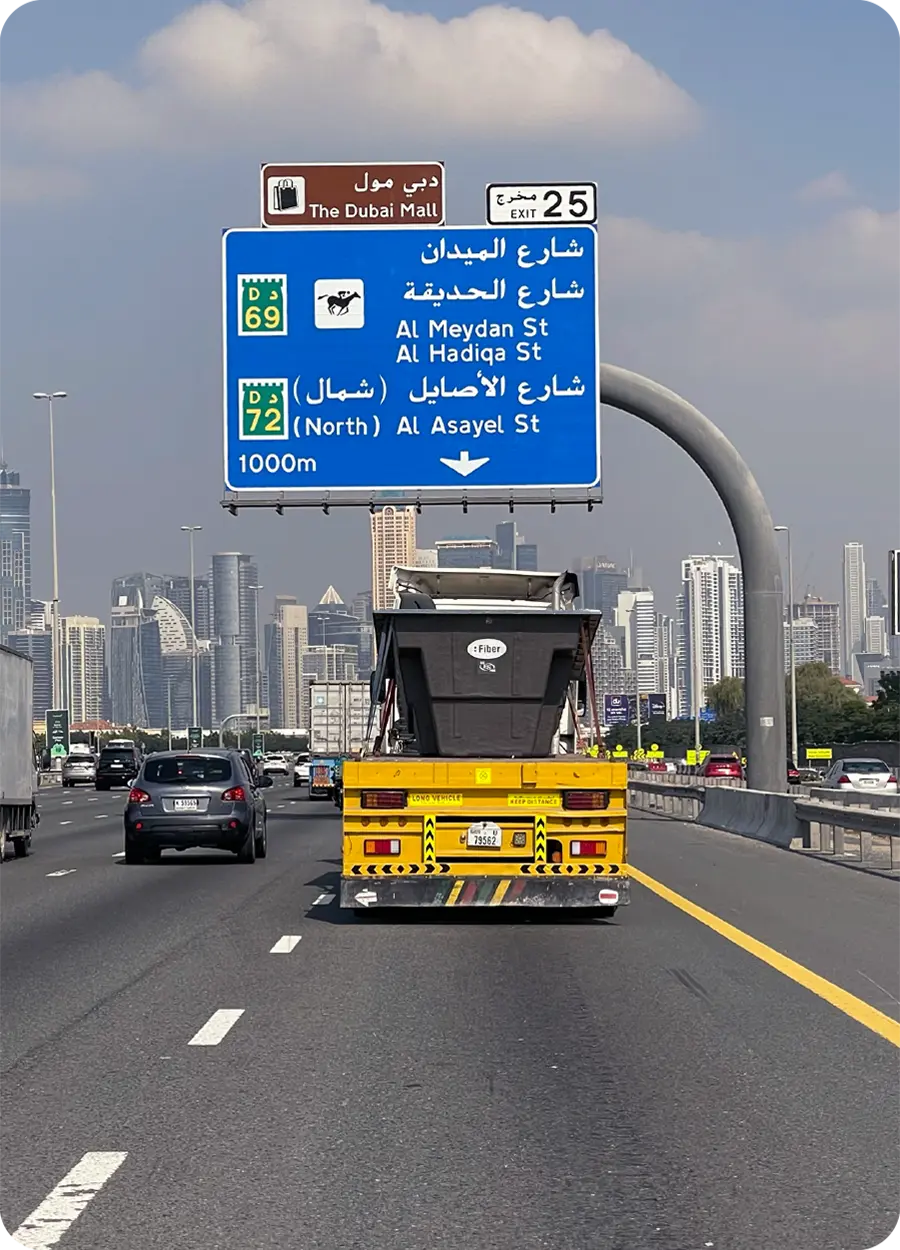 Highway in Dubai with Arabic road sign and skyline in the background, representing Fiber's international expansion