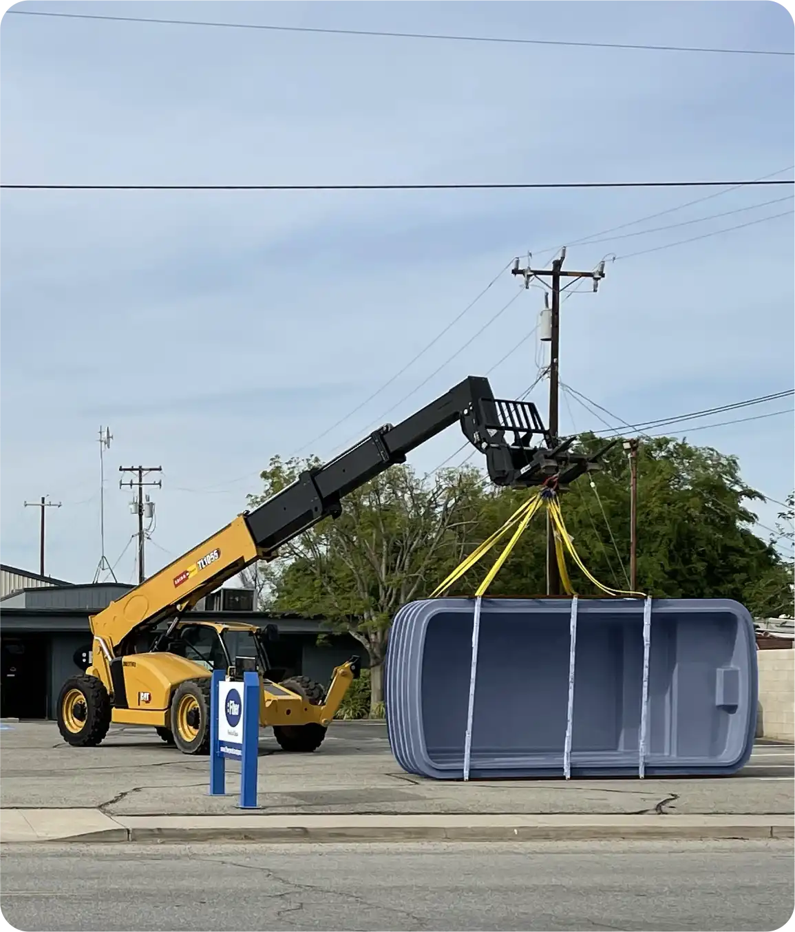 Crane equipment handling and positioning fiberglass pool on project jobsite