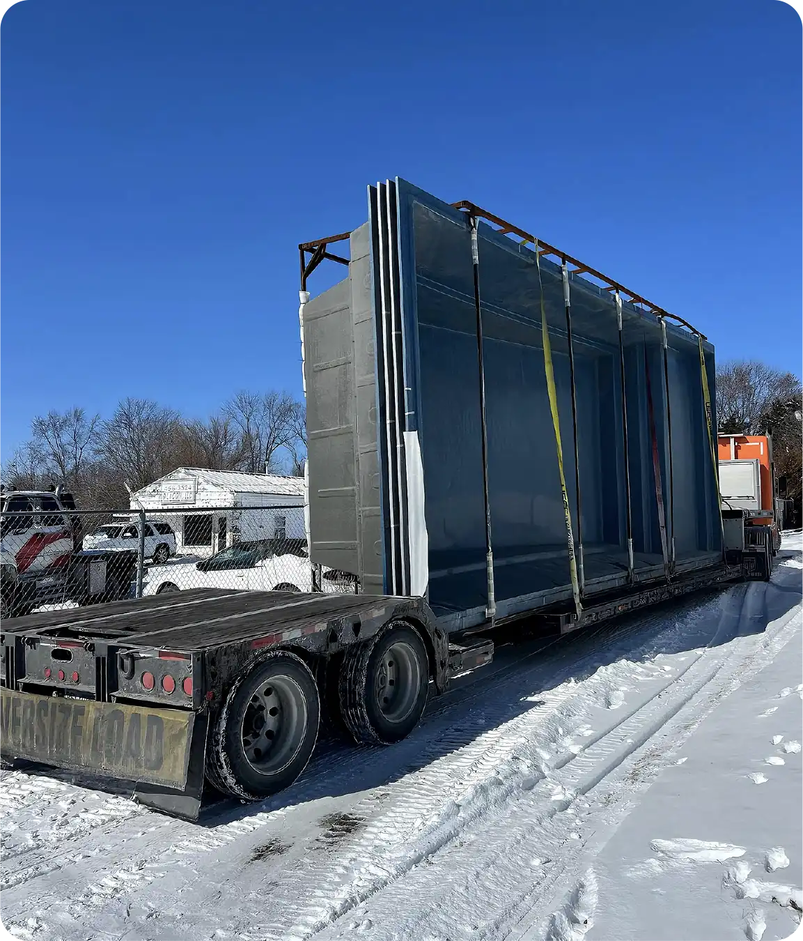 Fiberglass pools loaded onto flatbed transport truck for delivery from factory to jobsite