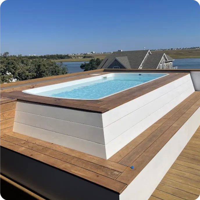 Completed fiberglass pool design with water on townhome rooftop deck