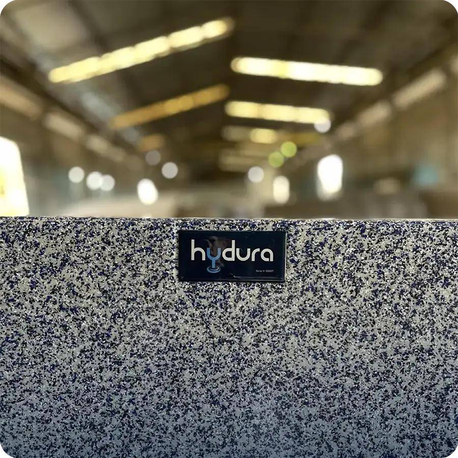 Speckled Hydura private label pool surface with factory production in the background